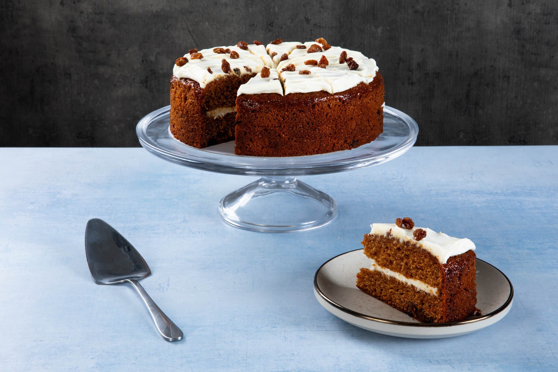 Carrot & Sultana Gateaux Carrot and sultana gateaux with cream icing and sliced piece.